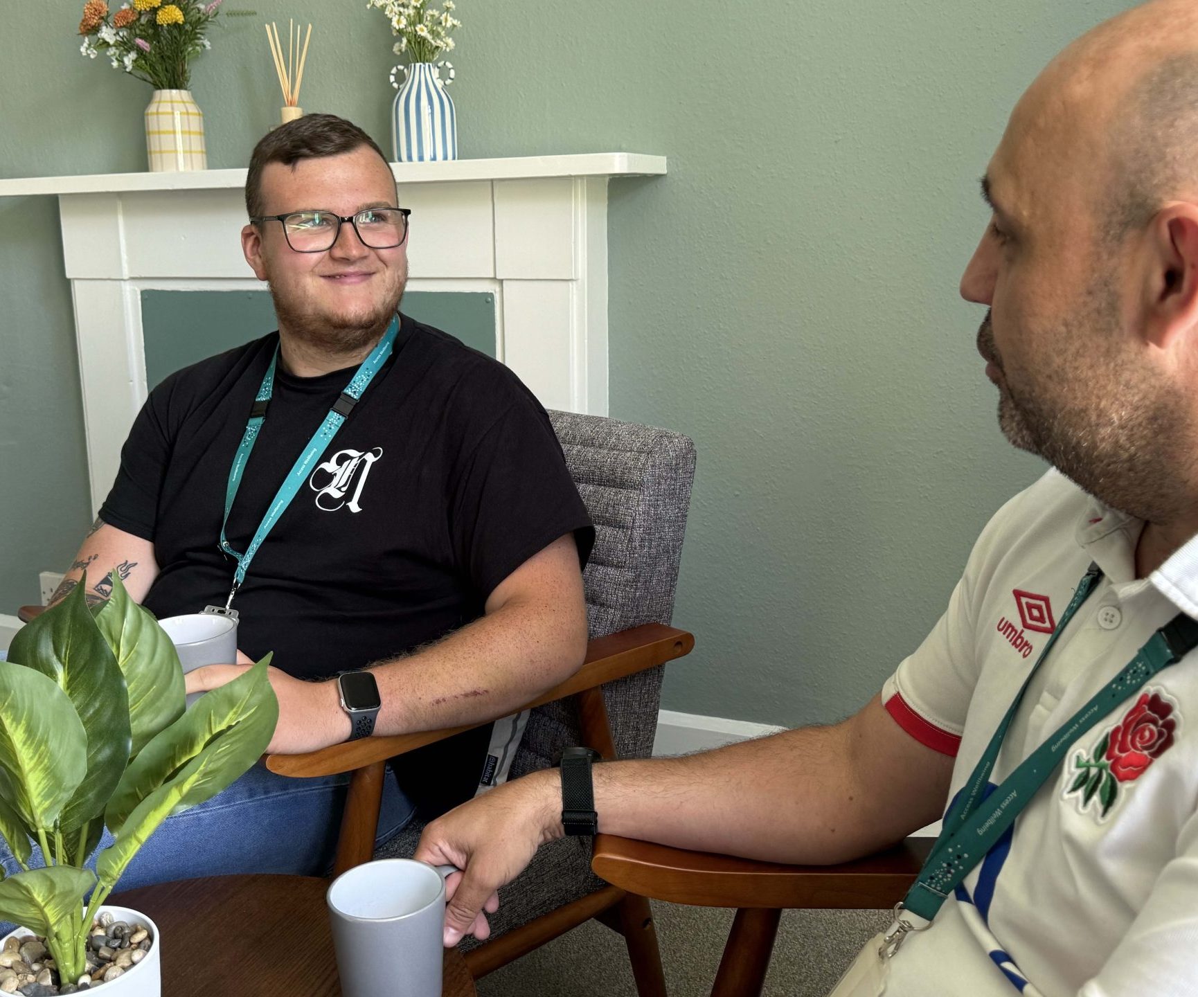 Two wellbeing coordinators chat and drink tea